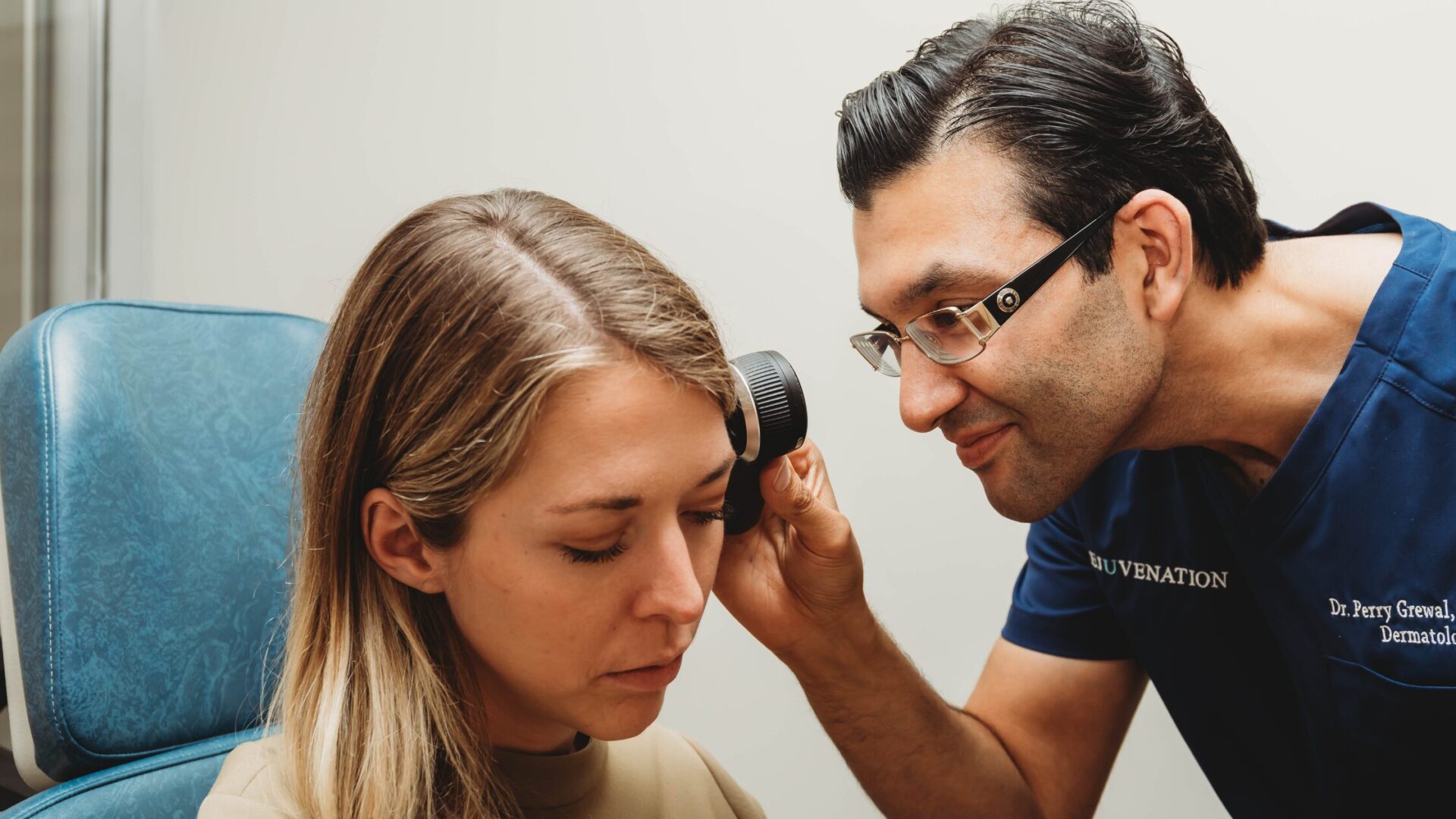 Dr. Perry Grewal specialized in dermatology and examines a patient's skin closely, assessing for any irregularities, conditions, or areas of concern. 